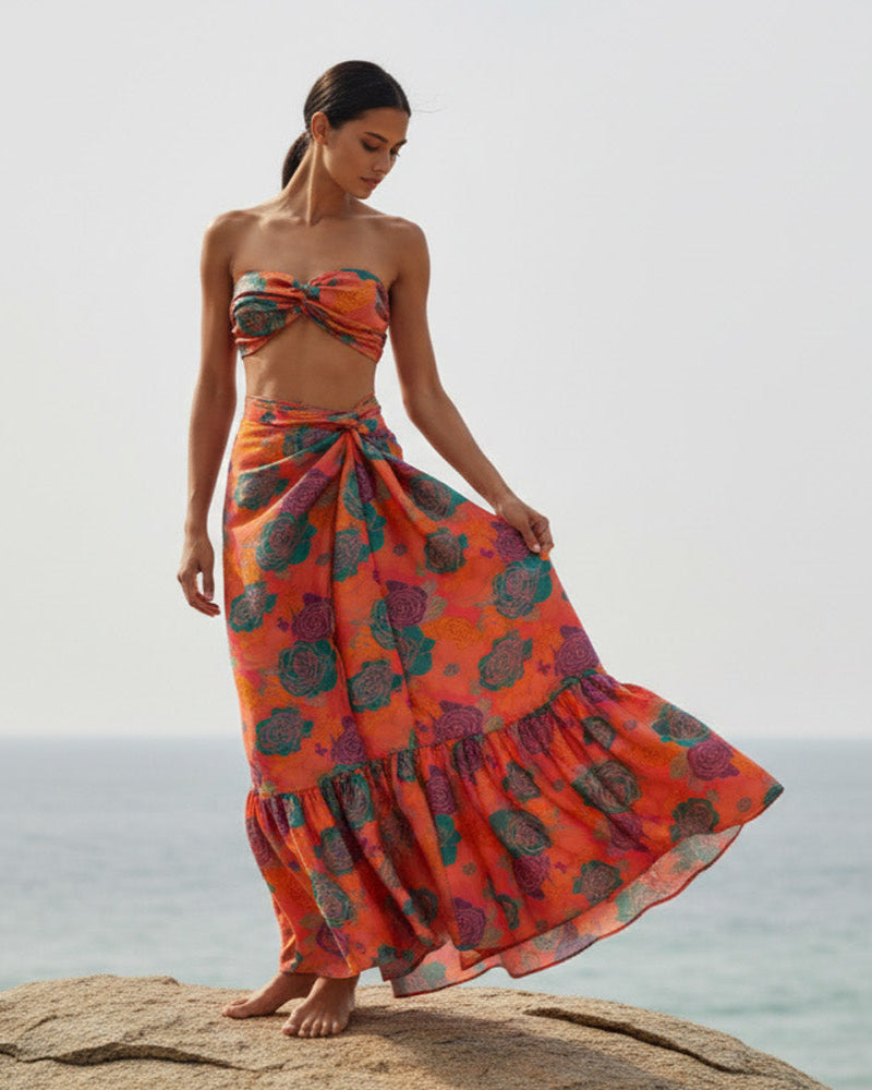 Woman in a colorful dress standing on rocks by the ocean - AMARIS